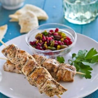 Cinnamon and cumin flavor these easy Baharat chicken skewers. With apomegranate relish, tahini yogurt sauce and pita make an exotic weeknight dinner.