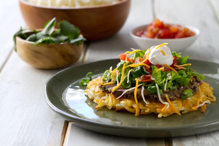 Frozen hash browns replace a tortilla in these Vegetarian Hash Brown Tostadas. Topped with lime and cilantro black beans it makes an easy 30 minute vegetarian dinner.