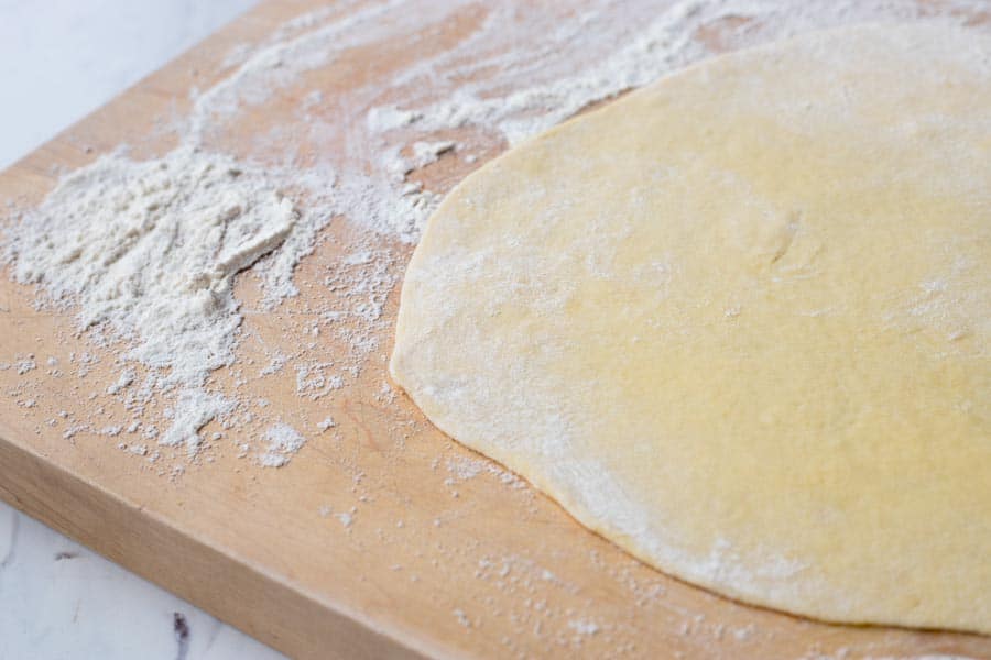 Tarte-flambee-french pizza Rolled dough on a board for the Tarte Flambee.