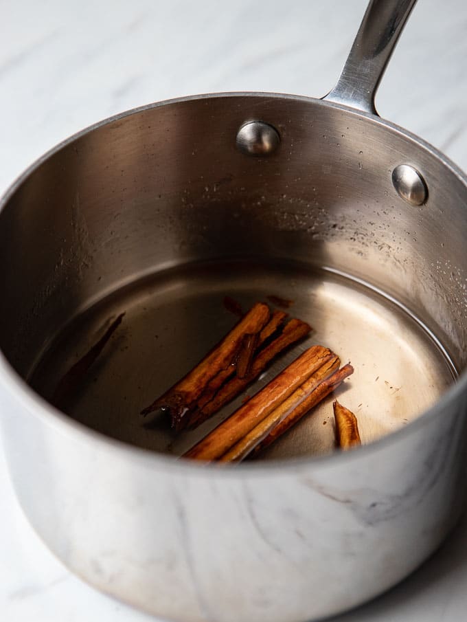 Saucepan with cinnamon infused simple syrup for gin gimlet cocktail