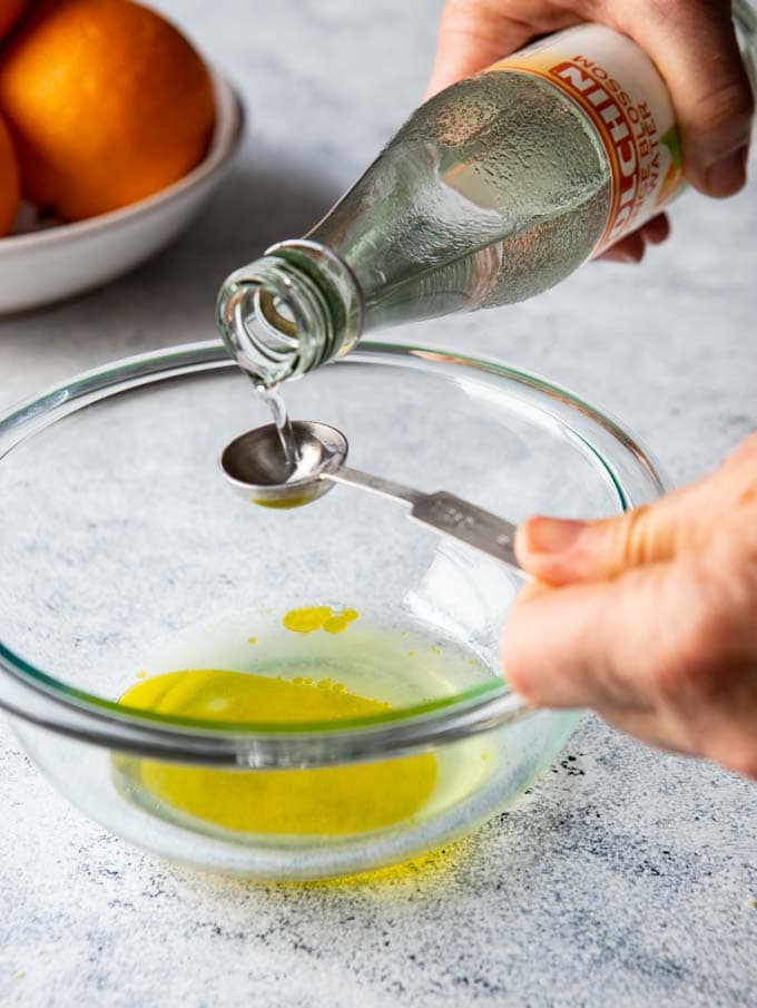moroccan-citrus-salad Pouring orange flower water into a bowl to make the Moroccan Citrus salad dressing.