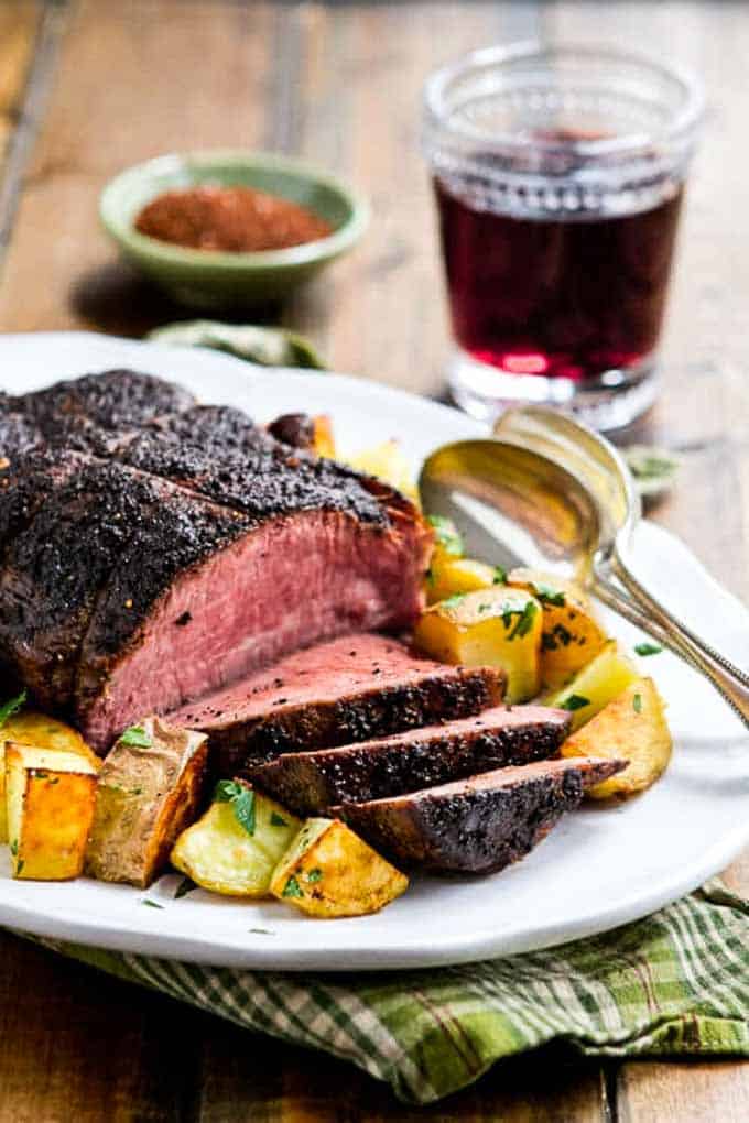 Sliced Sirloin roast on a platter with potatoes. 