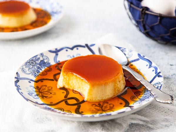 Close up of traditional 
Spanish flan recipe with a portion removed to show the inside of the flan.


