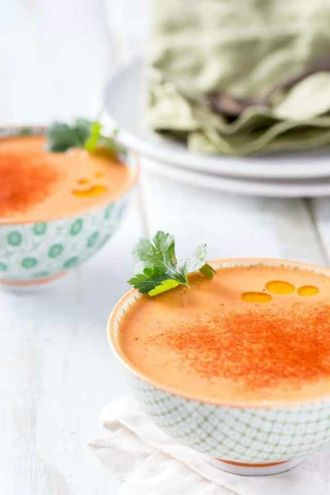 Two bowls of Spanish Garbanzo bean soup with plates and napkin in the background.