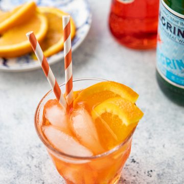 Glass of Spritz Veneziano with orange slices in the background