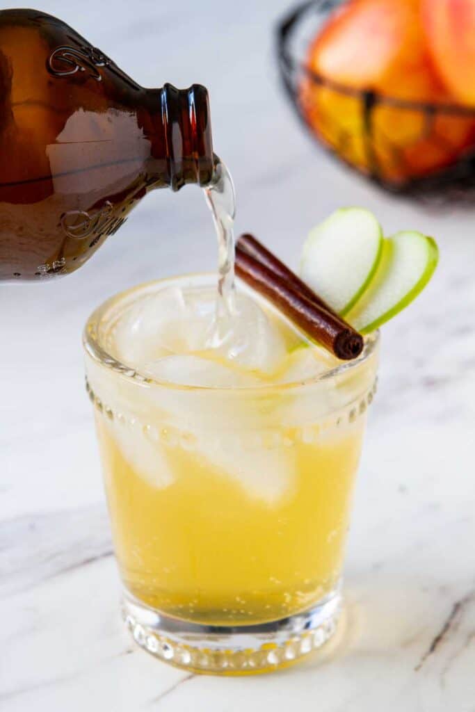 Easy Sparkling Spiced Cider Ginger beer being poured into an apple cider cocktail.
