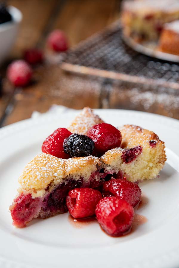 plate with a slice of butter cake and raspberry liqueur infused berries. 