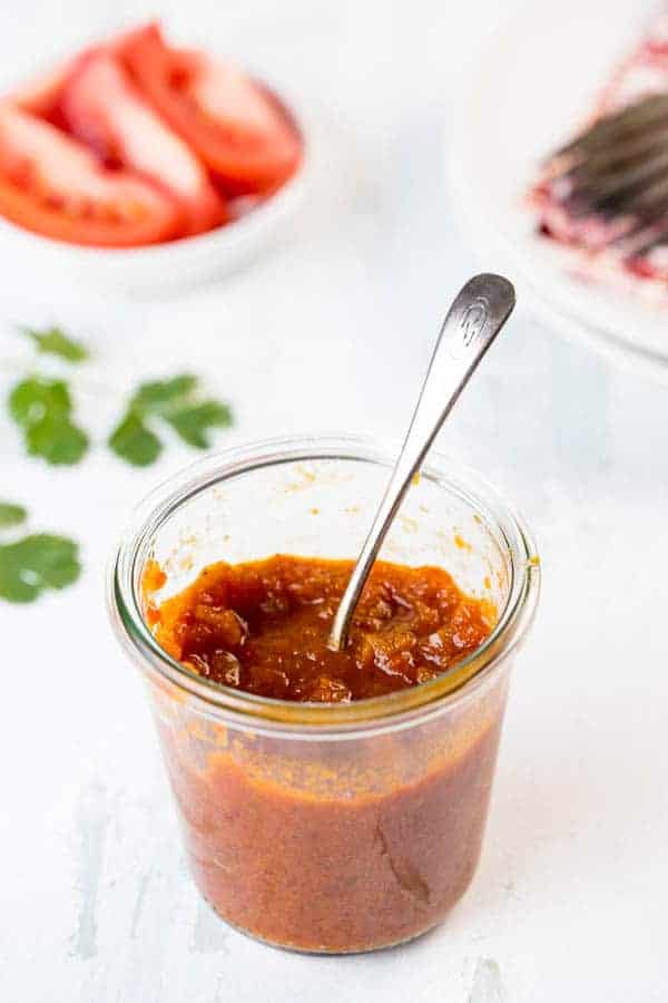 Sweet, sour and spicy, this Tomato Chutney is everything you love about ketchup - but better! Flavored with ginger , curry and a little chile, you'll want to slather this chutney on everything - chicken, fish, steaks, sandwiches and vegetables! A quick saute and simmer is all it takes for this riff on an Indian classic! glass jar with tomato chutney