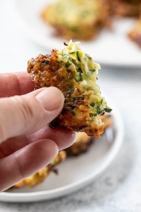 Fingers holding a piece of zucchini cake