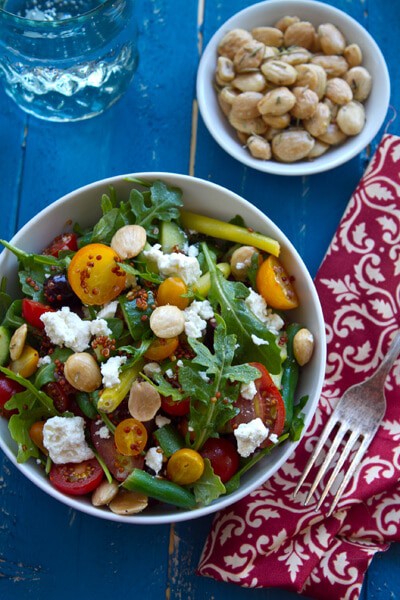 Easy and healthy Mediterranean Quinoa Salad recipe with a lemon vinaigrette. Tomatoes, arugula, feta and almonds combine in this make ahead side dish!