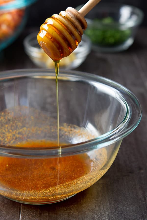 moroccan-carrot-salad honey drizzling into dressing for Carrot Salad with Moroccan Spices