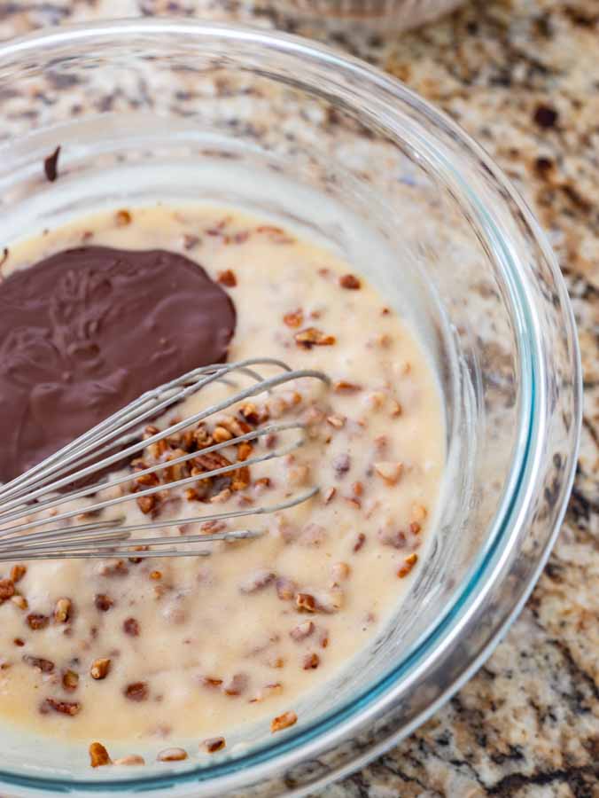 Wet and dry ingredients with melted chocolate being whisked together for this ooey gooey chocolate cake.