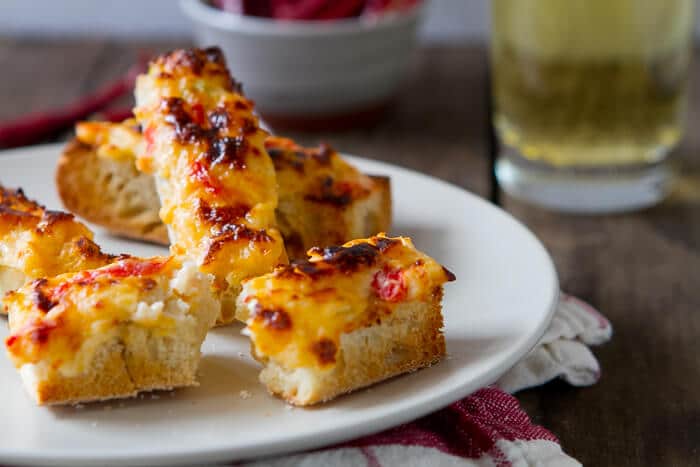 This Easy Queso Dip Bread recipe has it all - gooey cheese, tomatoes and spicy chiles! Make a big batch ahead and enjoy gooey, cheesy Queso anytime!