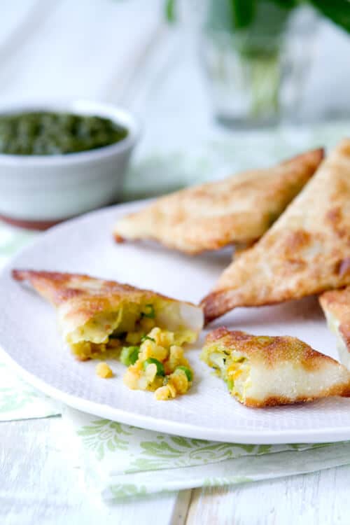 These shortcut vegetarian Samosas with Mint Chutney are filled with potatoes, peas and lentils and ready in under 45 minutes.