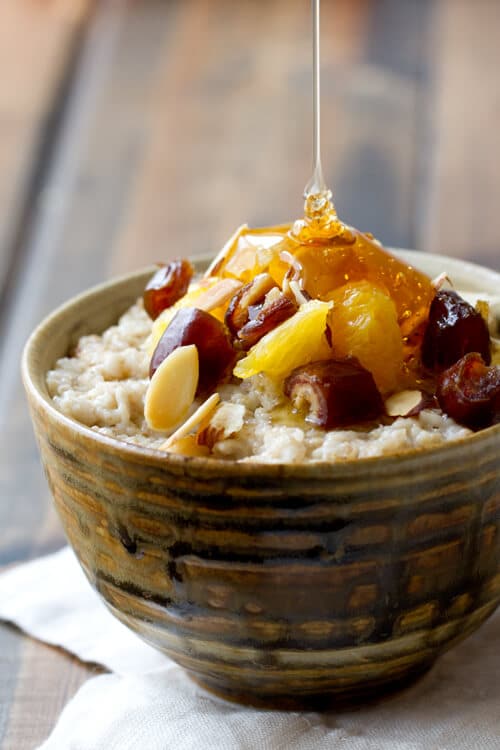 honey drizzled on a bowl of Orange and date Oatmeal- a healthy oatmeal breakfast