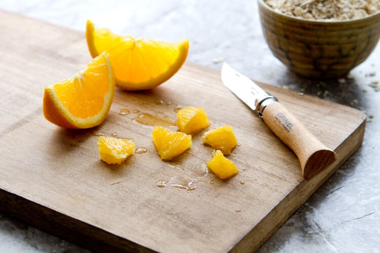 chopped up oranges on a board for the orange and date Oatmeal