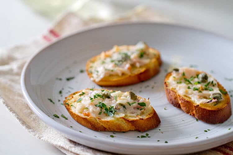 Finished scampi style shrimp toast on a plate. 