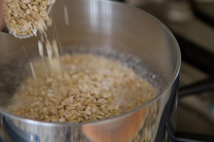 pouring oats into the pan for Orange and date oatmeal