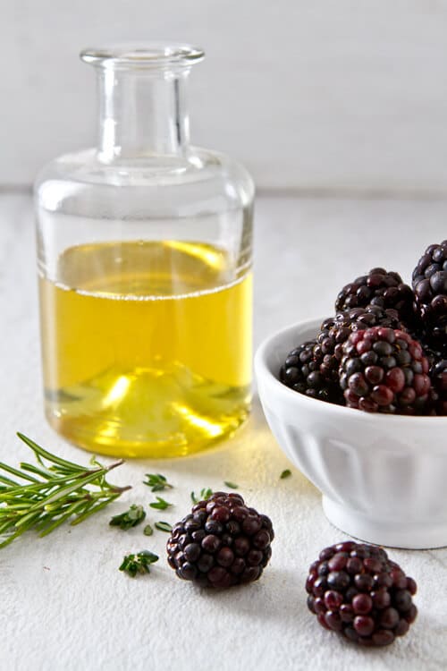 rosemary and thyme infused simple syrup in a jar for the bramble drink