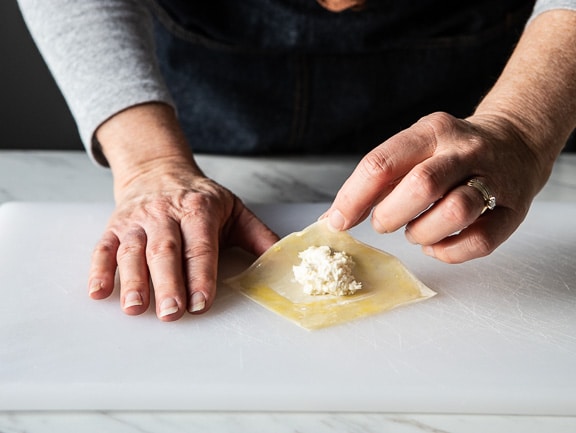 folding the wonton wrapper over the crab rangoon filling.