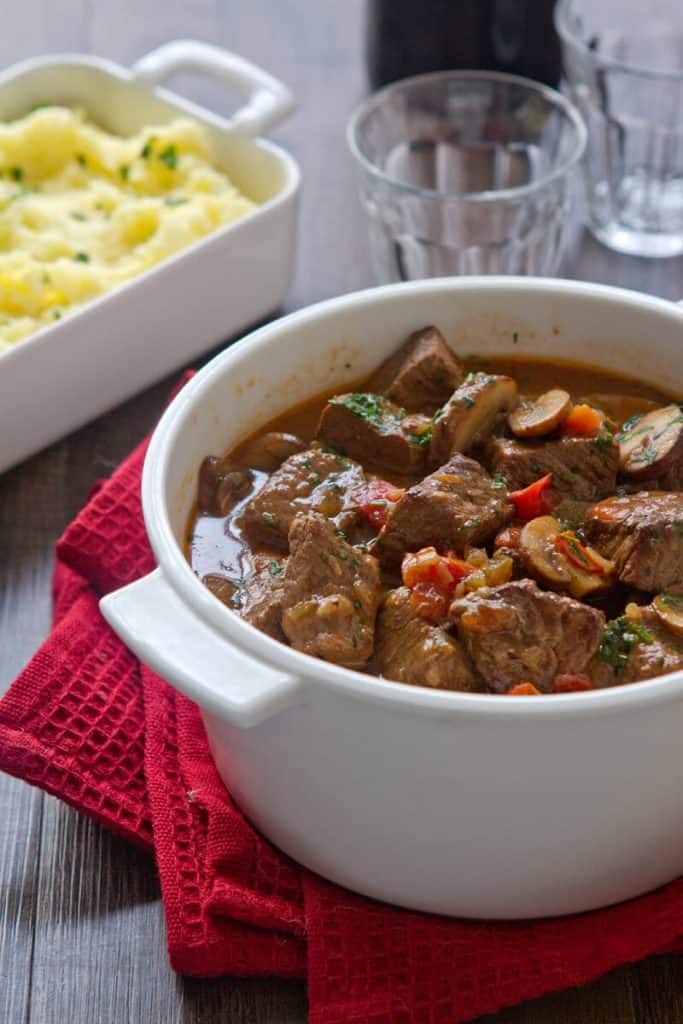 Casserole dish with Hunter's Stew and a side of potatoes