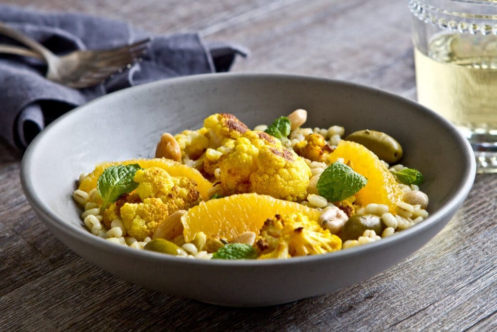 a bowl of moroccan citrus, cauliflower and barley salad