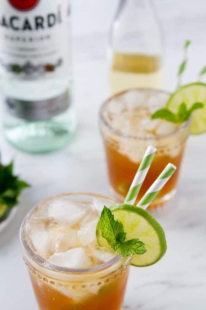 Two glasses of this rum moscow mule with a bottle of bicardi in the background. 
