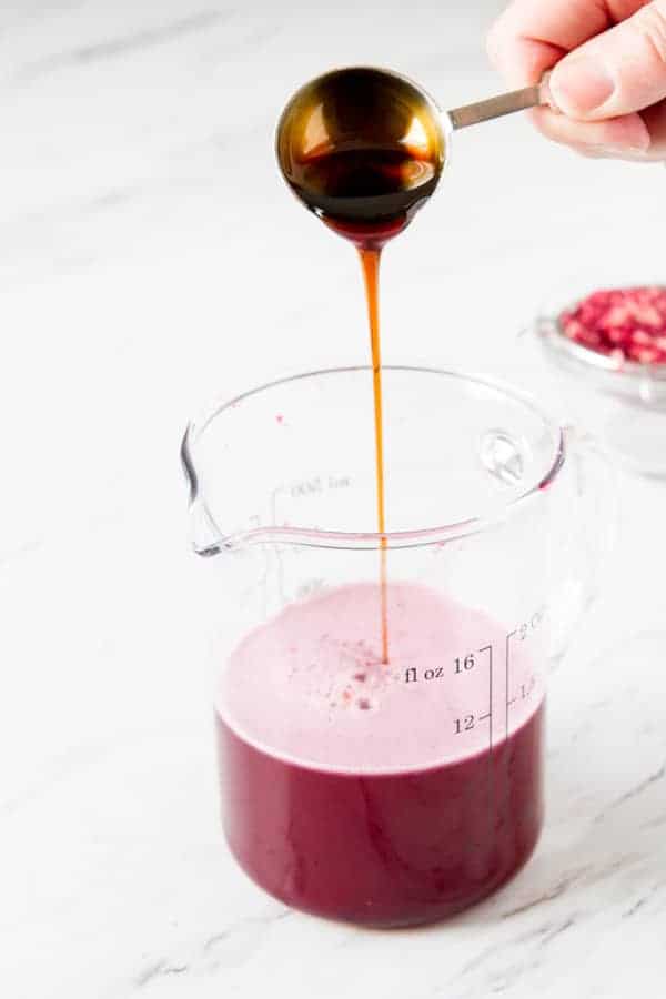 Third step in how to make grenadine - adding the pomegranate molasses to the pomegranate juice