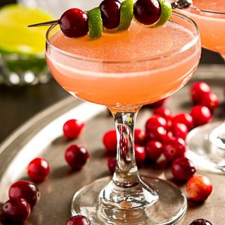 Sweet, tart and not too boozy, this easy vodka Ruby Red Cosmopolitan cocktail recipe is just right for a holiday or winter party.