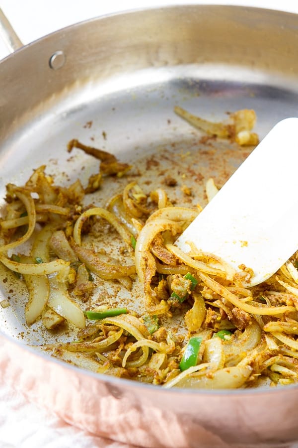 Skillet with onions, chiles, and spices used in Coconut Chicken Curry