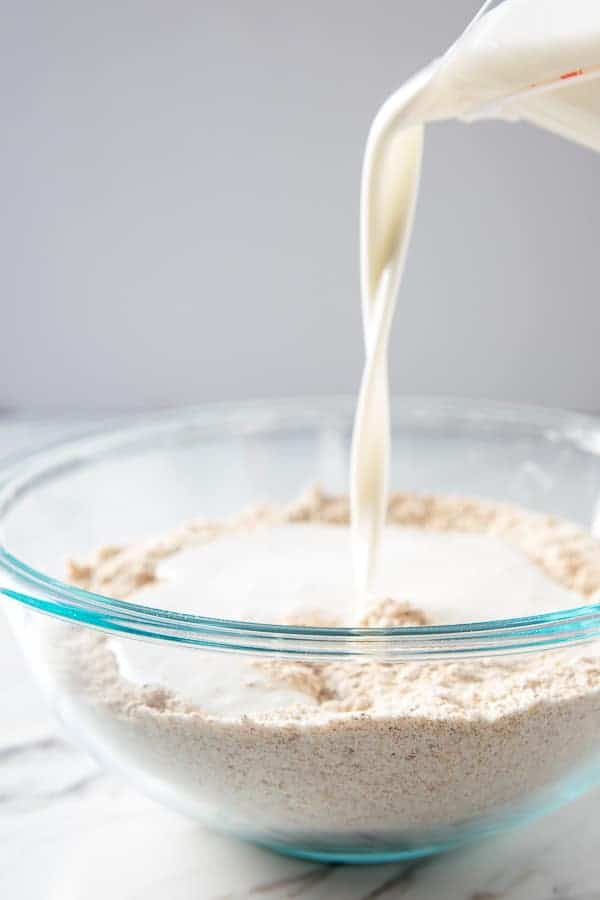 pouring buttermilk into flours for irish brown bread