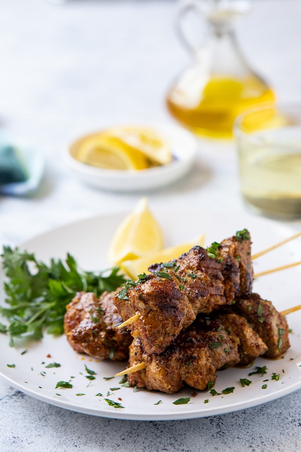 Plate with Ras El Hanout grilled Pork skewes with lemon and parsley