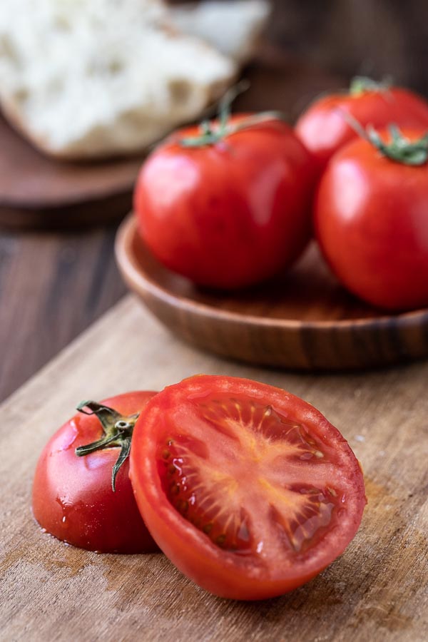 sliced tomato for this spanish appetizer on a board with tomatoes. 