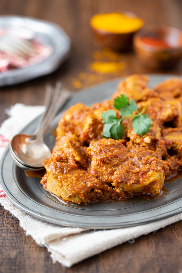 Madras Chicken, an Indian Chicken curry recipe, on a platter with two serving spoons