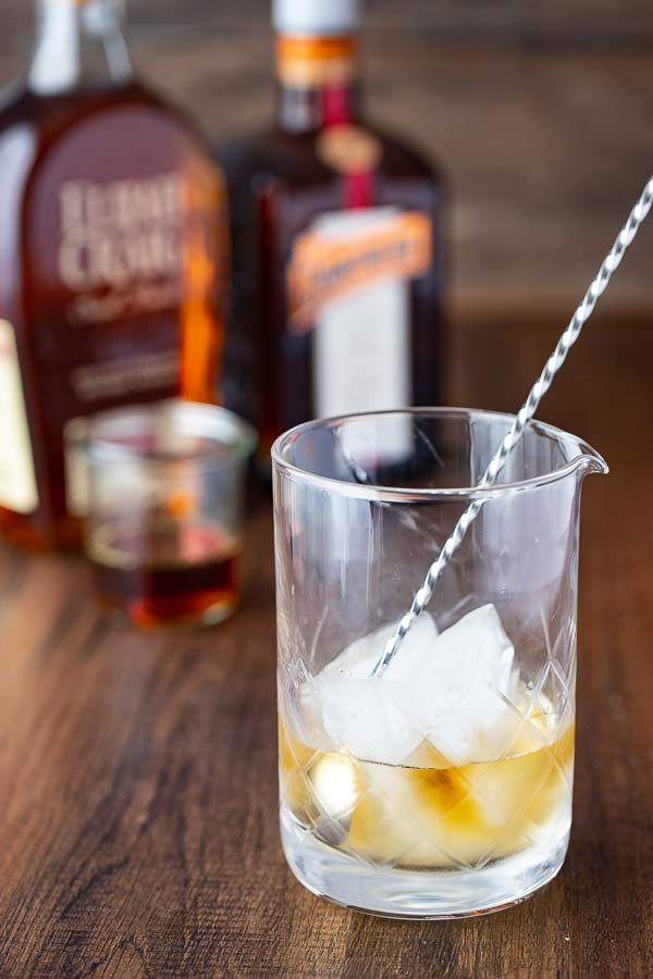 bourbon, honey and orange liqueur  in a mixing glass for making the best  old fashioned bourbon recipe.
