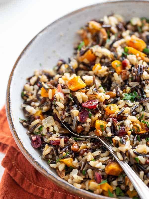 bowl with baked butternut squash and wild rice pilaf with a spoon