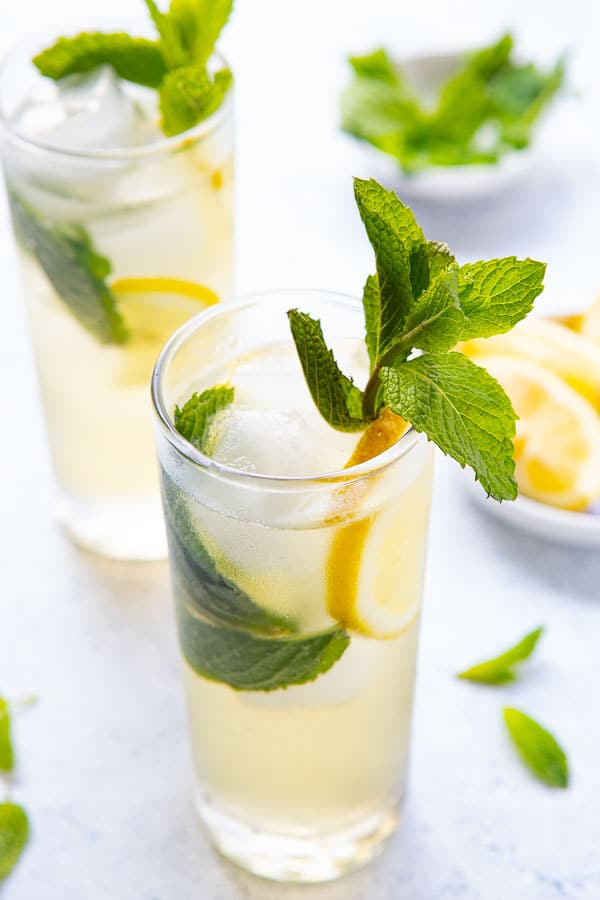 close up shot of the ginger rogers, a gin and ginger ale cocktail with a sprig of mint garnish.