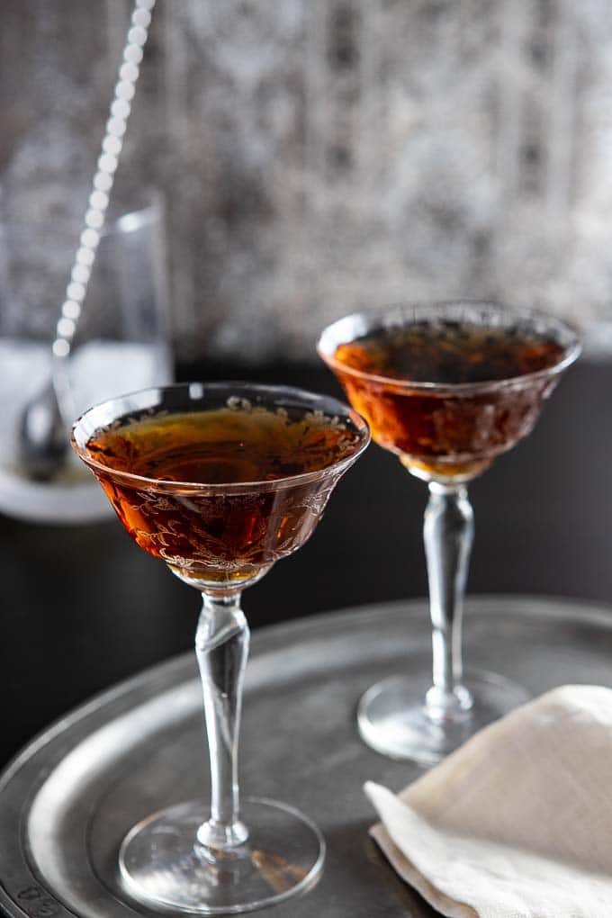 Two glasses of bourbon amaretto cocktail on a tray.