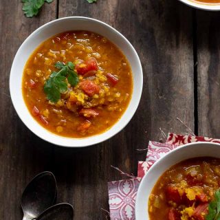 Bowls of spiced red lentil soup with coriander