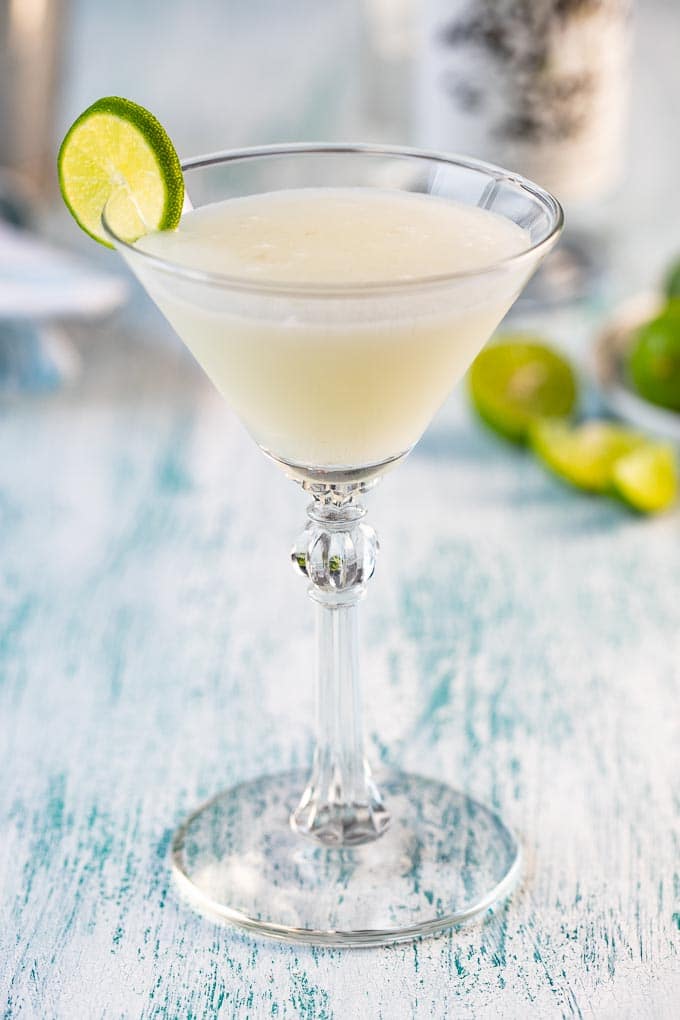 Martini glass with key lime martini garnished with a lime slice.


