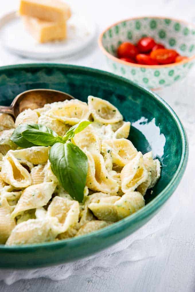 Close up shot of the pasta with yogurt sauce garnished with a sprig of basil.