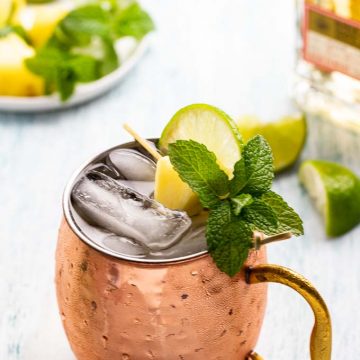Single mug of a Mexican Mule with a garnish of mint, lime and pineapple.