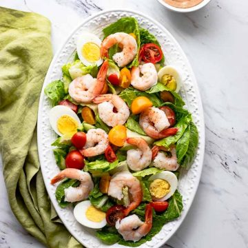 Overhead shot of Shrimp Louie Salad with a side of dressing.