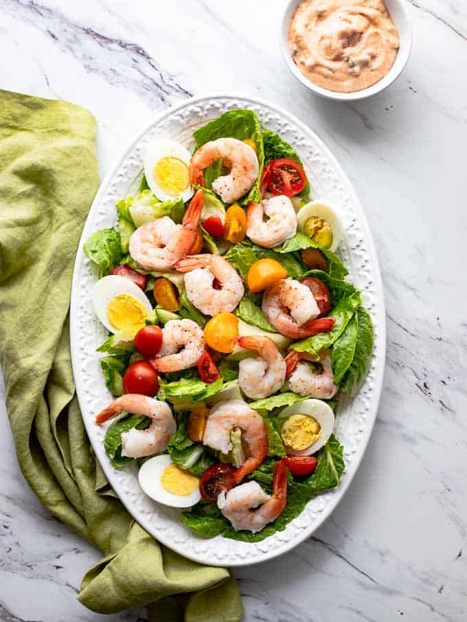 Overhead shot of Shrimp Louie Salad with a side of dressing.