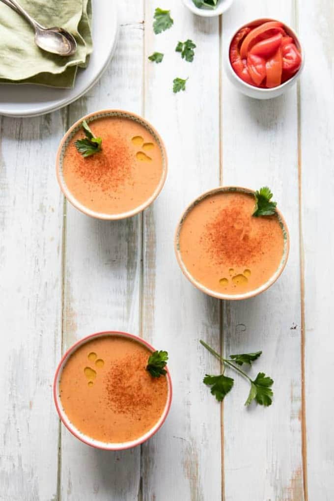 Overhead photo of 3 bowls of this Creamy Chickpea soup with a garnish of fresh parsley.
