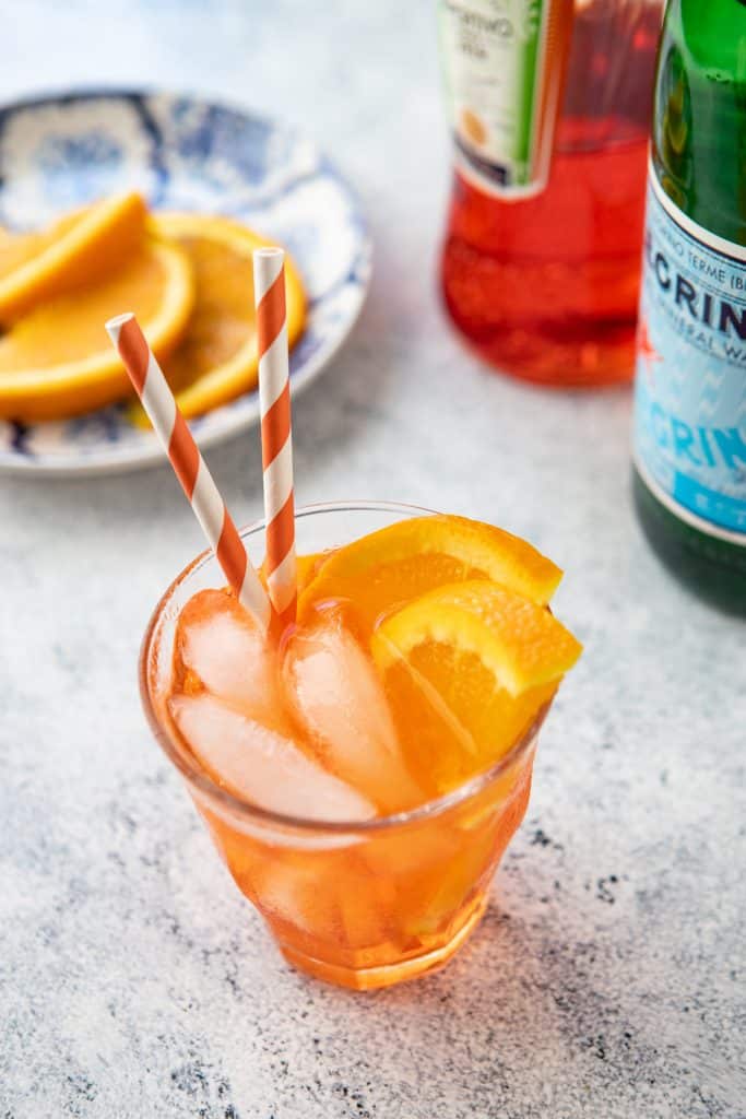 Glass of Spritz Veneziano with orange slices in the background