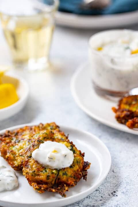 zucchini cakes with dipping sauce on a plate