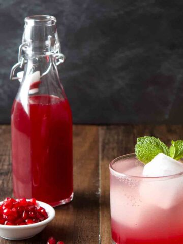 Bottle of grenadine with pomegranate seeds