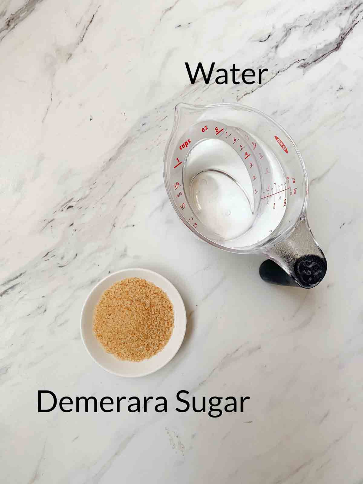 a measuring glass of water and dish of demerara sugar, the ingredients for demerara sugar. i